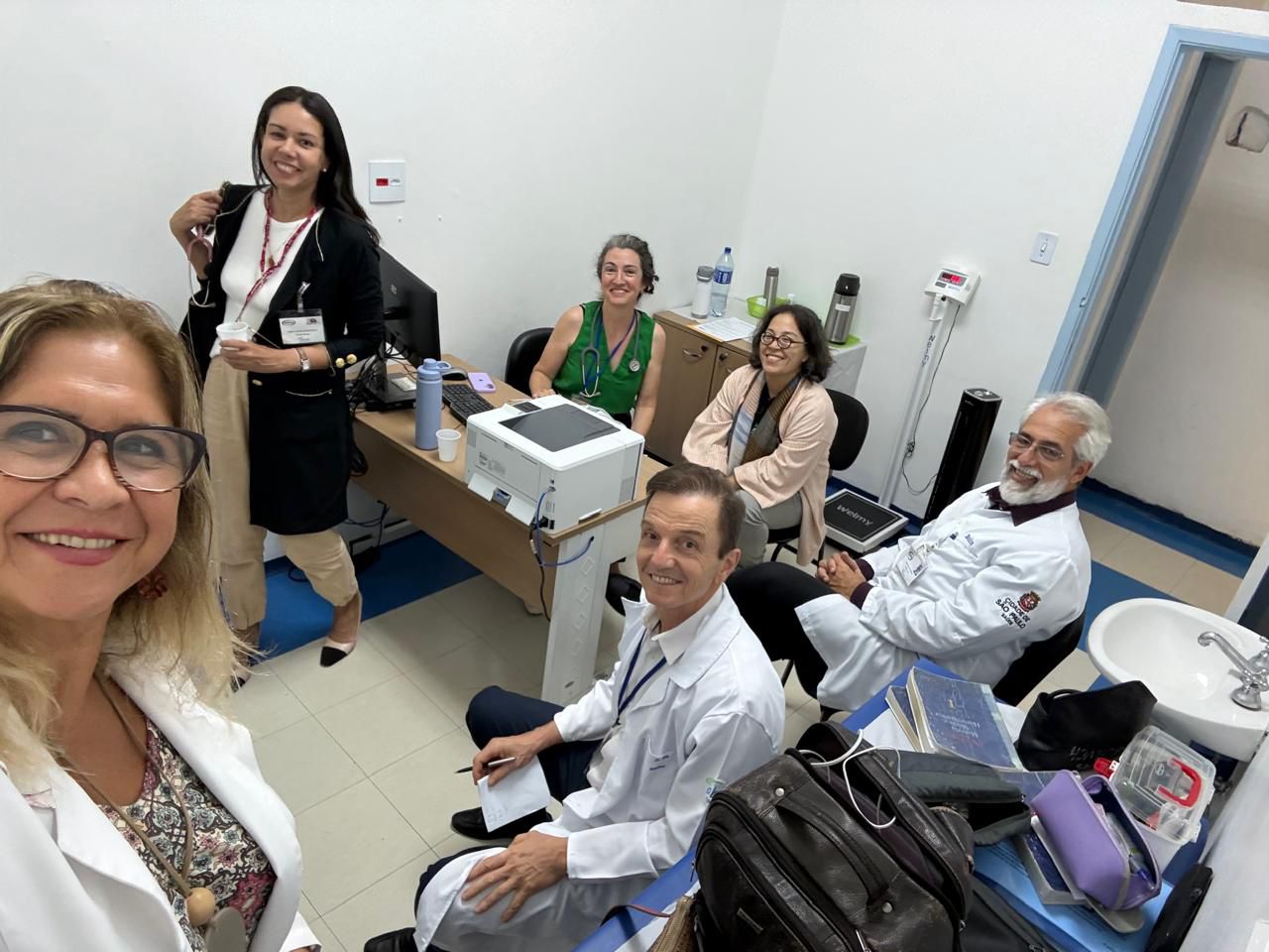 Grupo de médicos discutindo casos clínicos durante formação em Homeopatia com supervisão especializada.